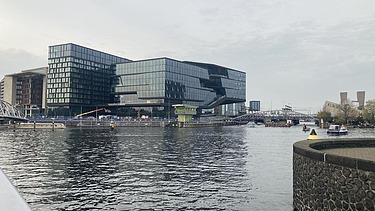 Foto von der „ODE“ in Amsterdam, mit Blick über einen Fluss.   