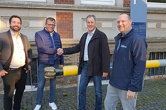 Foto vom vier Männer die lächelnd in die Kamera schauen. 