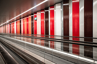 Foto von einer Rolltreppe mit einer bunten Wand.                