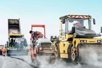 Foto zeigt drei Straßenbaumaschinen im Einsatz mit Fahrern