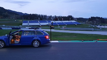 Foto von Vermessungsarbeiten am Red Bull Ring, am Straßenrand steht ein blauer PKW