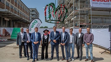 Foto von mehreren Personen vor einer Richtkrone.  