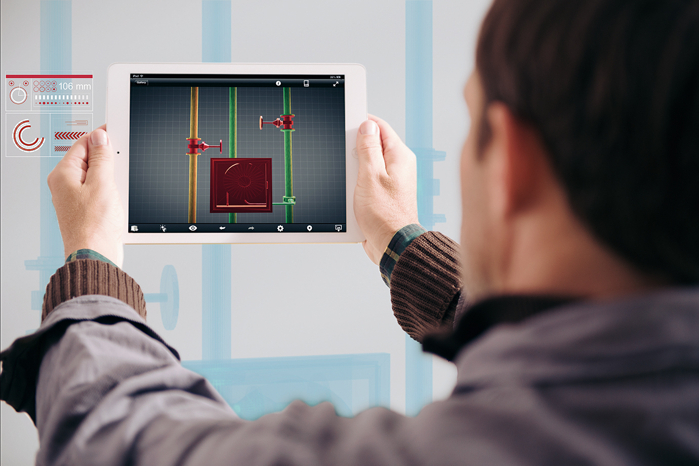 Photo of a person seen from behind holding a tablet in his hands