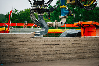 Photo of a photo of an automatically controlled boom of the Instatiq P1 concrete printer