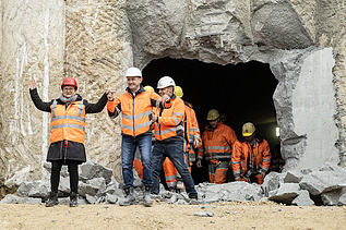 Nahaufnahme von mehren Personen in Schutzausrüstung beim feierlichen Durchschlag zur Wendlinger Kurve.