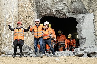 Nahaufnahme von mehren Personen in Schutzausrüstung beim feierlichen Durchschlag zur Wendlinger Kurve.