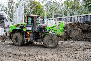 Ein großer Radlader transportiert Erde in seiner Schaufel