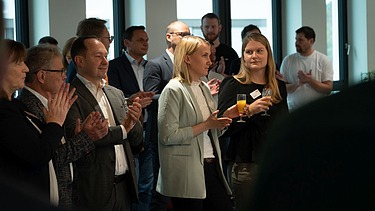 Foto von mehreren Personen die in die Hände klatschen.  