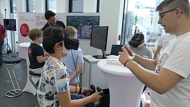 Foto von Kindern die mit Starbag Mitarbeitern VR-Brillen testen. 