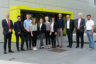 Foto von mehreren Personen die freundlich schauen.     