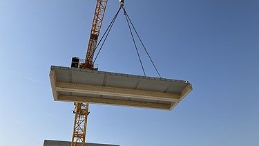 Kran hebt ein Bauteil in die Luft
