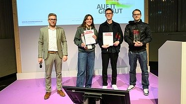 Foto von vier Personen auf einer Bühne. 