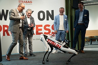 Foto von mehreren Personen, die einen Roboterhund in Aktion zuschauen. 