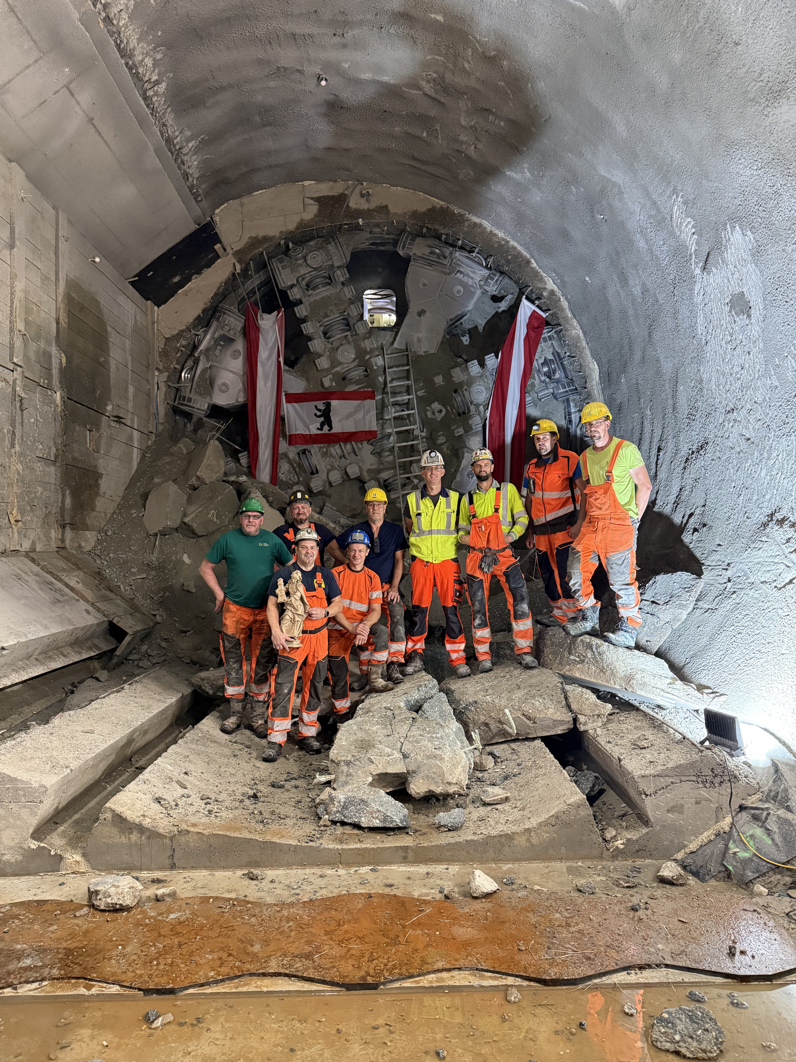 Mitarbeitende der ARGE U2 17-21 vor der Tunnelvortriebsmaschine Debohra nach dem erfolgreichen Tunneldurchschlag am Augustinplatz