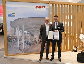 Zwei Männer mit Urkunde vorm ZÜBLIN-Forschungspreis Banner. 