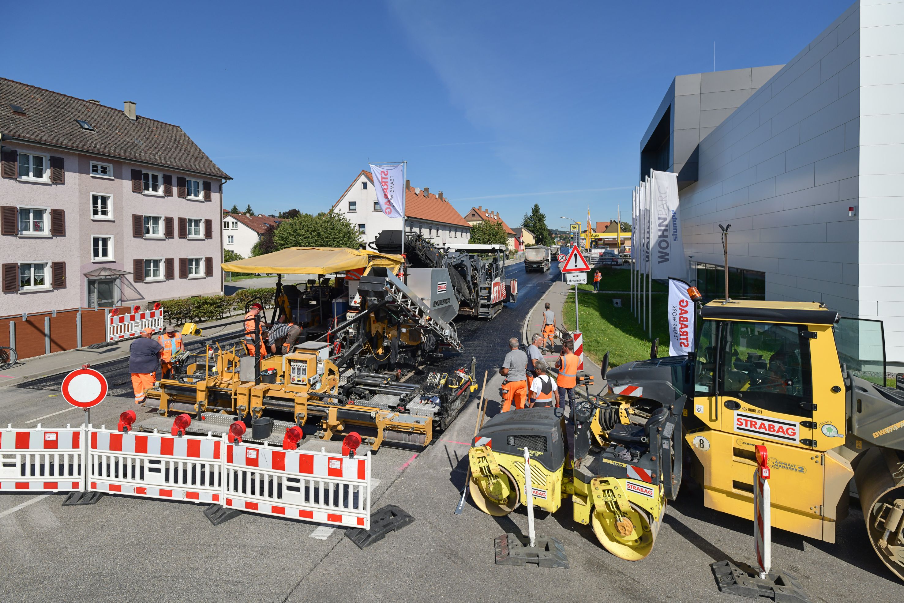 Foto einer Straßenbaustelle im Vordergrund eine weiß-rote Absperrung