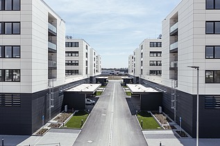 Visualisierung vom IN-Campus mit vier symmetrisch angeordnete Gebäudemodule in U-Form, mit Blick zwischen den Gebäuden. 