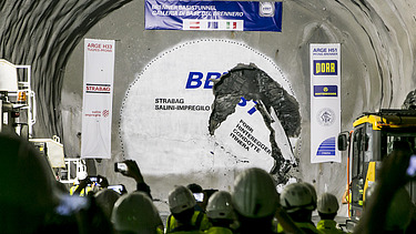 Foto einer Feier in einem Tunnel bei erlofgtem Durchbruch, an den Wänden hängen Transparente