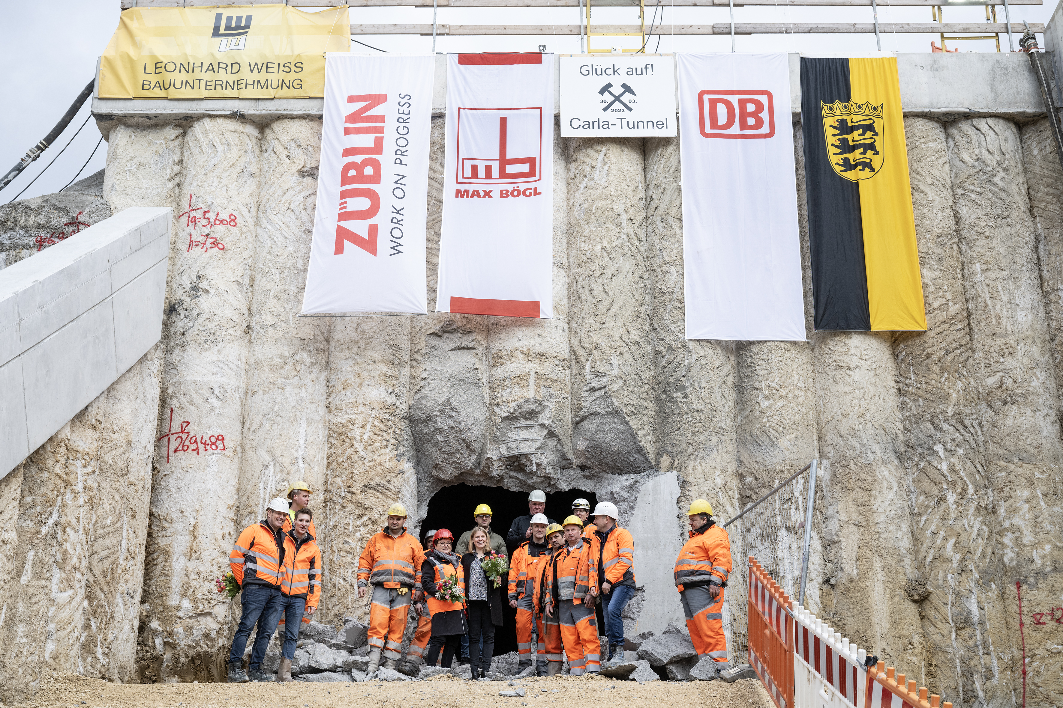 Foto von mehren Personen in Schutzausrüstung beim feierlichen Durchschlag zur Wendlinger Kurve.