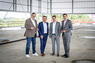 Foto von vier Personen, die in einer Halle stehen