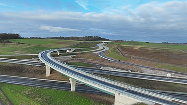 Foto aus der Vogelperspektive. Es ist eine Autobahn von oben zu sehen.