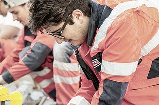The picture shows two people in work clothes at work