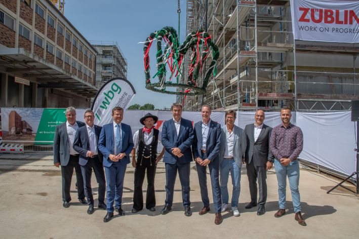 Foto von mehreren Personen vor einer Richtkrone.  