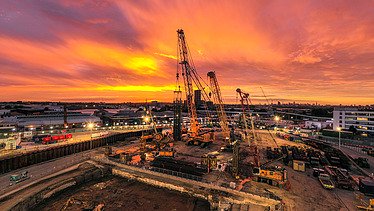 A building site with cranes at sunset