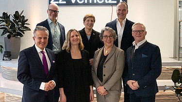 Das Bild zeigt fünf Personen, die vor einer Lichtinstallation stehen