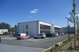 Foto von einem Parkplatz vor einem Bürogebäude.  