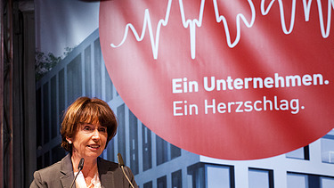 Foto von der Oberbürgermeisterin von Köln, die vor einem Pullt steht und eine Rede hält.  
