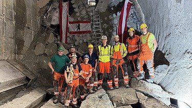 Mitarbeitende der ARGE U2 17-21 vor der Tunnelvortriebsmaschine Debohra nach dem erfolgreichen Tunneldurchschlag am Augustinplatz