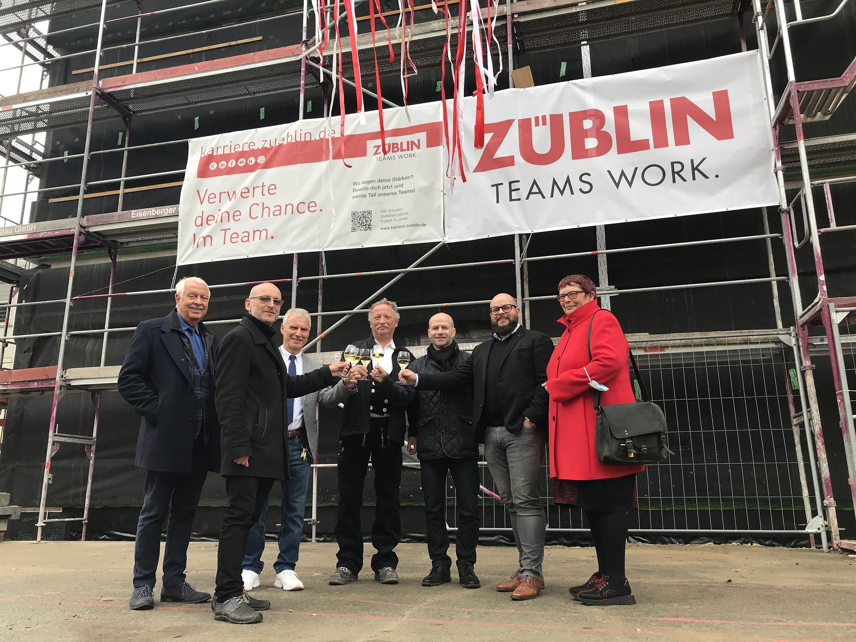 Foto von mehren Personen beim Anstoßen nach dem Richtstoß. 