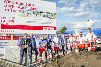 Das Foto zeigt mehrere Personen mit Schaufeln hinter einem Erdhaufen