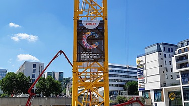 Foto von einem Kran mit International Dance Festival Plakat. 