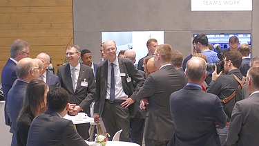 Foto vom Deutschen Bahntechnik-Tag 2019. Es herrscht freudige Stimmung und viele Männer sind zusehen. 