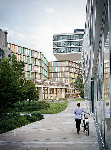 The picture shows an office building with a person and a bicycle