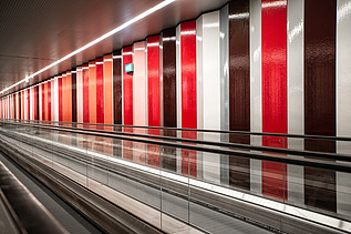 Foto von einer Rolltreppe mit einer bunten Wand.                