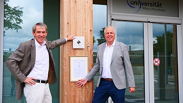 Foto von zwei Männern die freundlich schauen.   