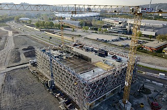 Foto einer Baustelle mit einem gelben Kran auf der rechten Seite