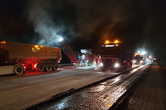 Foto zeigt Fräsarbeiten bei Nacht mit zwei Maschinen und mehreren Fahrzeugen