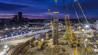 A building site with cranes at night