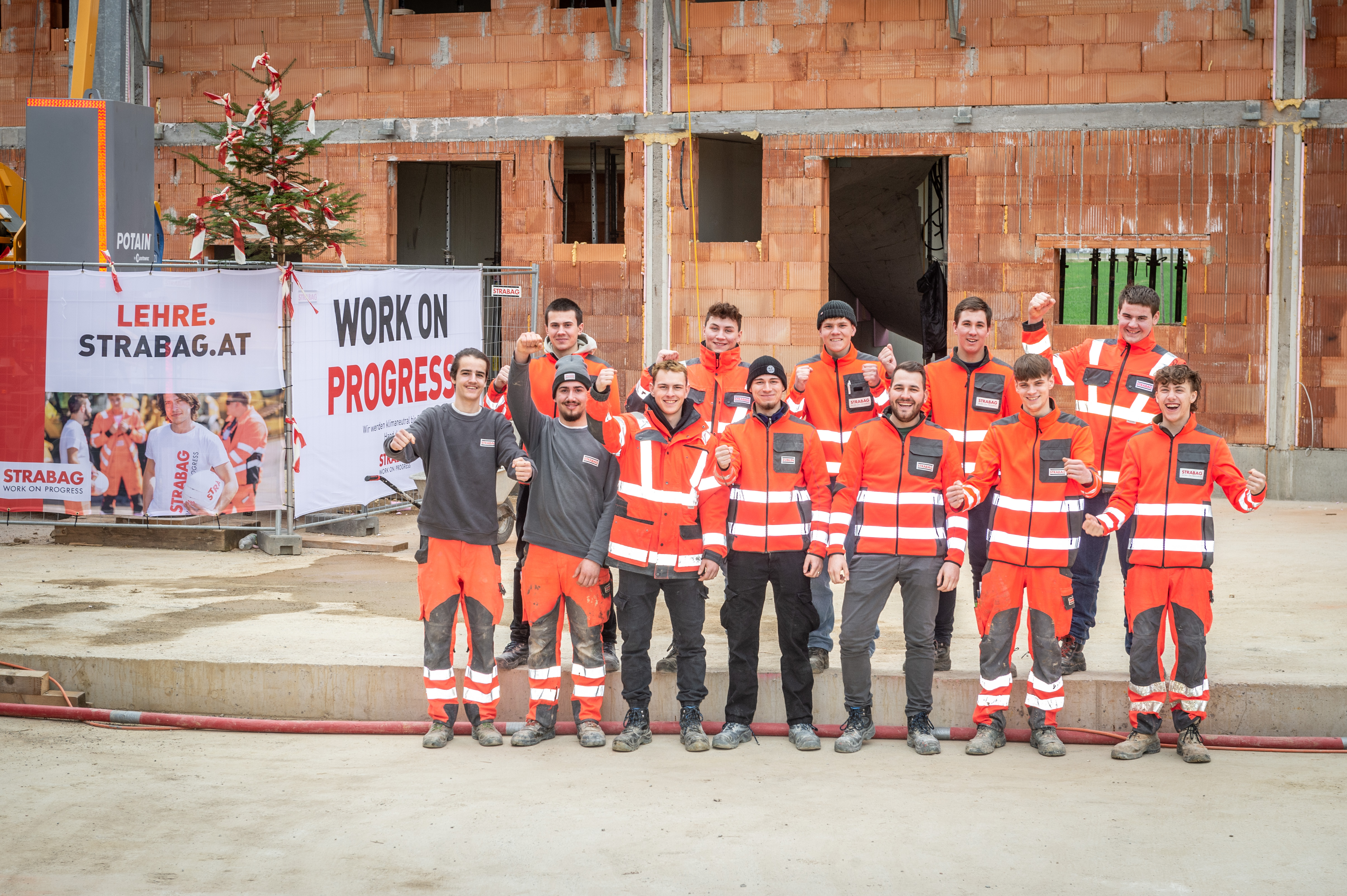 Foto von zwölf STRABAG Lehrlingen, die ein Haus errichteten