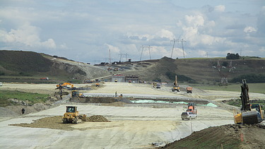Photo shows a highway construction site with several machines at work