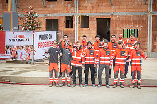 Foto von zwölf STRABAG Lehrlingen, die ein Haus errichteten
