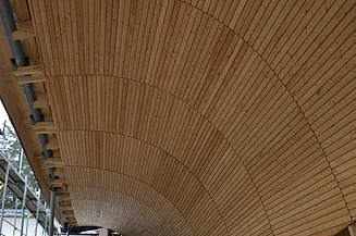 Foto von der Innenansicht einer Rennschlittenbahn mit Holzüberdachung.       