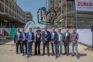 Foto von mehreren Personen vor einer Richtkrone.  