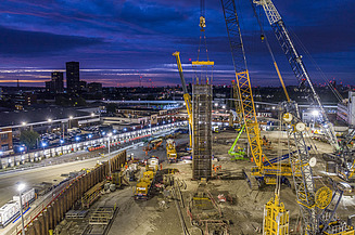A building site with cranes at night