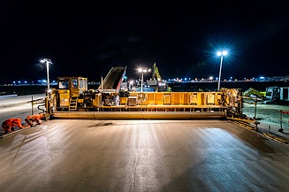 Foto einer gelben Betonbaumaschine bei Nacht bei Flutlicht