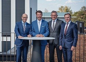 Foto von vier Personen, die an einem Stehtisch stehen